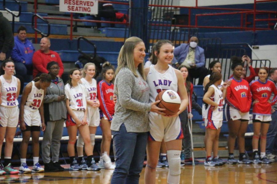 Senior Chloe McClain receives a basketball for becoming a member of the LadyKats' 1,000 points club. McClain was presented with the ball from the last member of the club, KHS graduate Audrey McDonald-Spencer. 