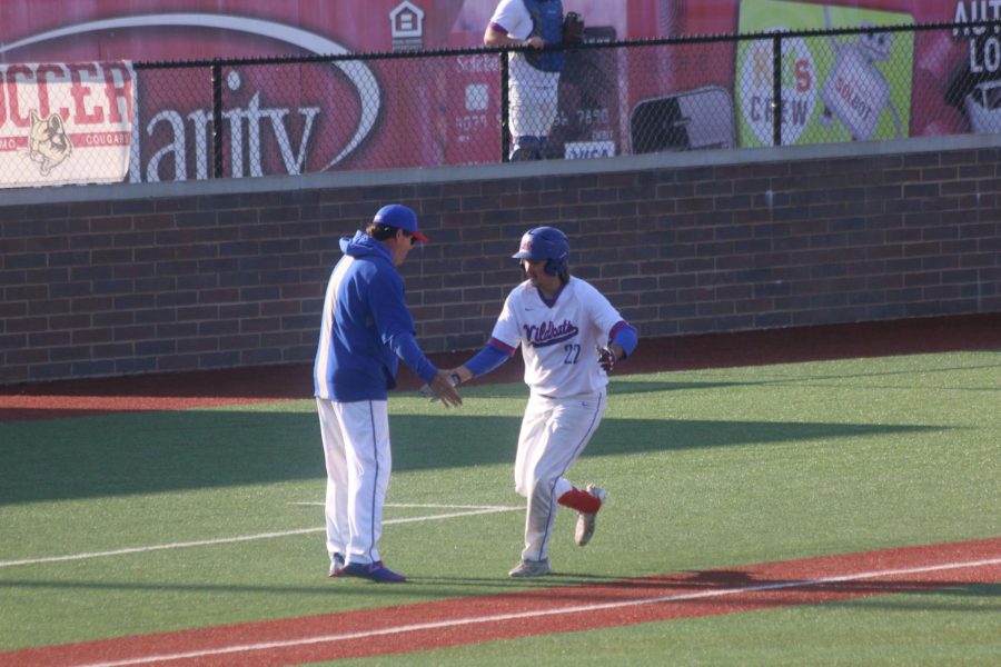 Junior John Curl is congratulated by his coach after hitting a home run. Curl hit two homeruns in the Kats' home win over McCutcheon last Tuesday. 