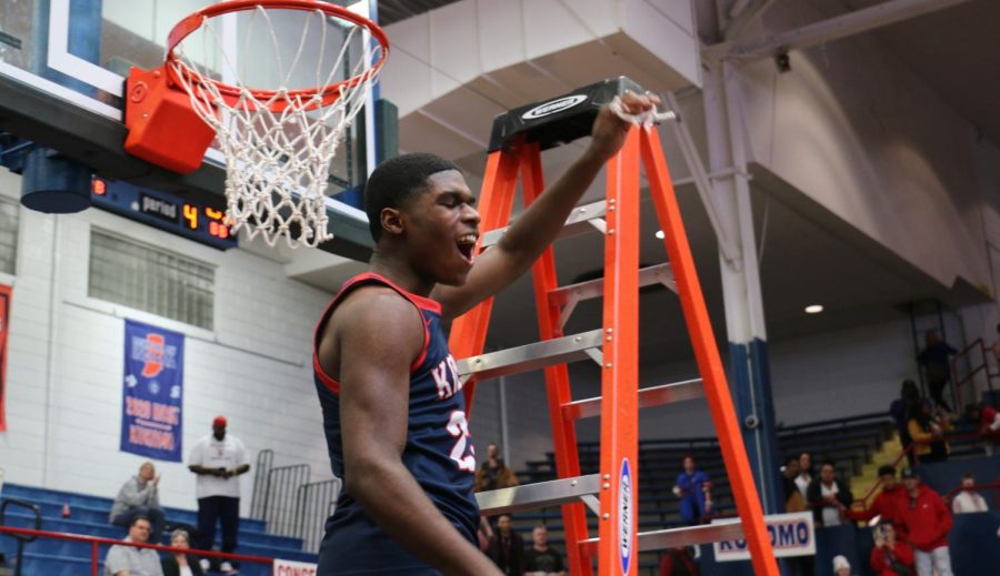 Senior Dre Kirby yells to the crowd after cutting down the net in Memorial Gym. Kirby and the Wildkats defeated the Marion Giants, 85-51, to claim their 76th sectional title. 