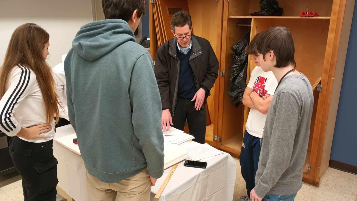 Students in Matt Myers US History class work with Gil Porter, a local historian, to set up their museum. 