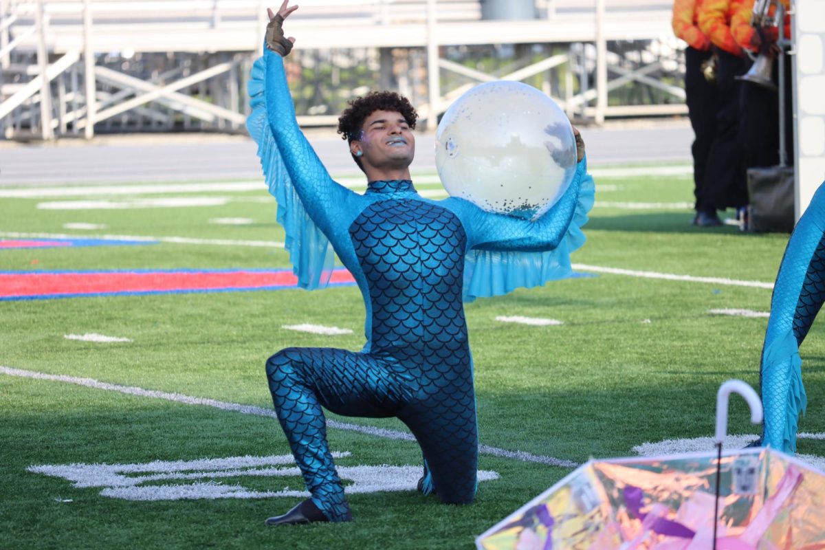 Senior color guard member Keegan Irick-Holliday takes his place on the field as the Marching Wildkats prepare for their ISSMA performance. The marching band and guard earned a gold rating with distinctions in music and visual. 