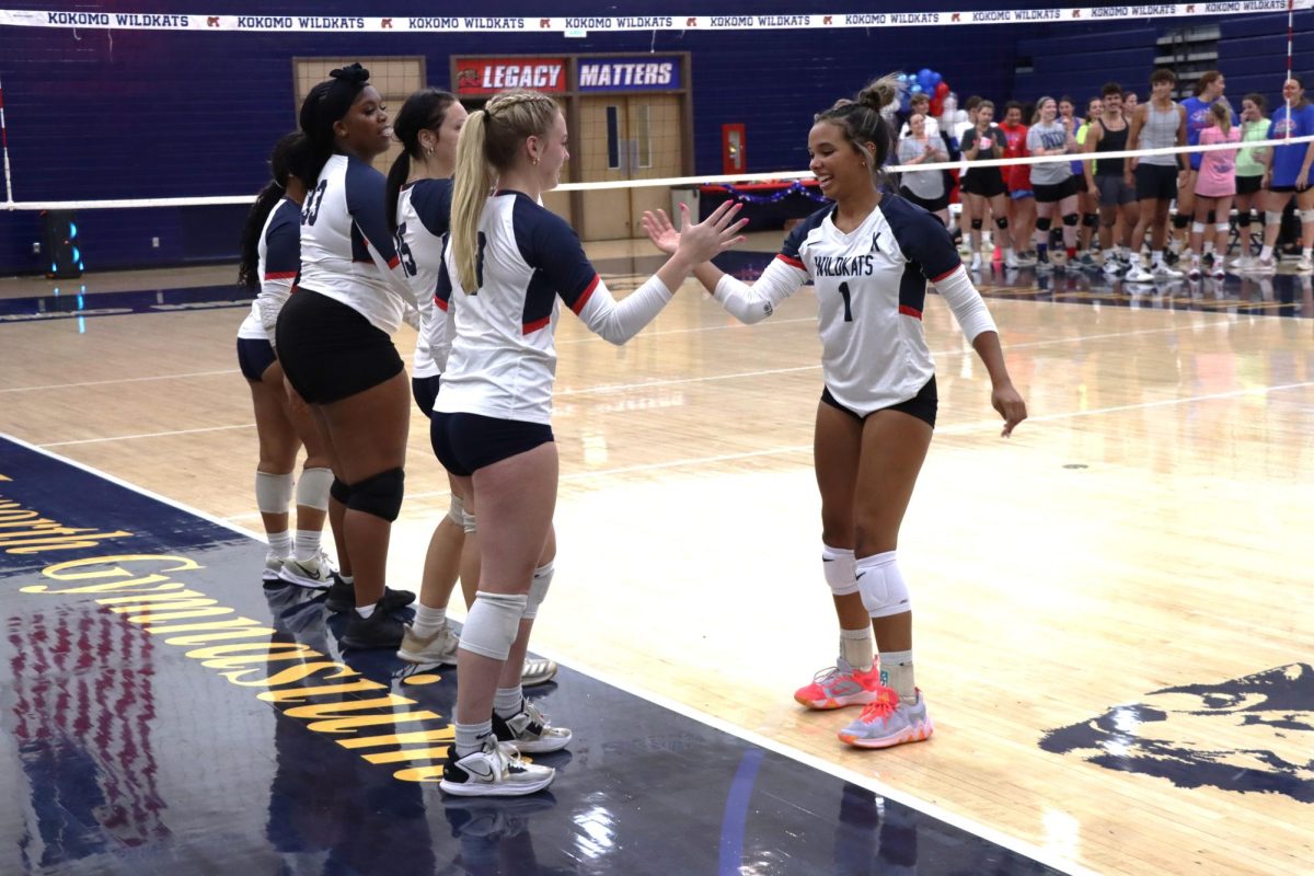 Senior Regan McClain and junior Tia Williams hype each other up while the alumni team looks on. The VolleyKats hosted the alumni game as a team fundraiser. 