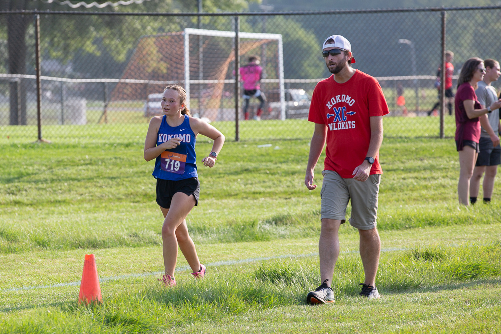 Cross country coach Jordan Ousley encourages junior Gretchen Riggle during an invitational at Logansport. The Kats will return to Logansport on Oct. 19 for the sectional meets. 