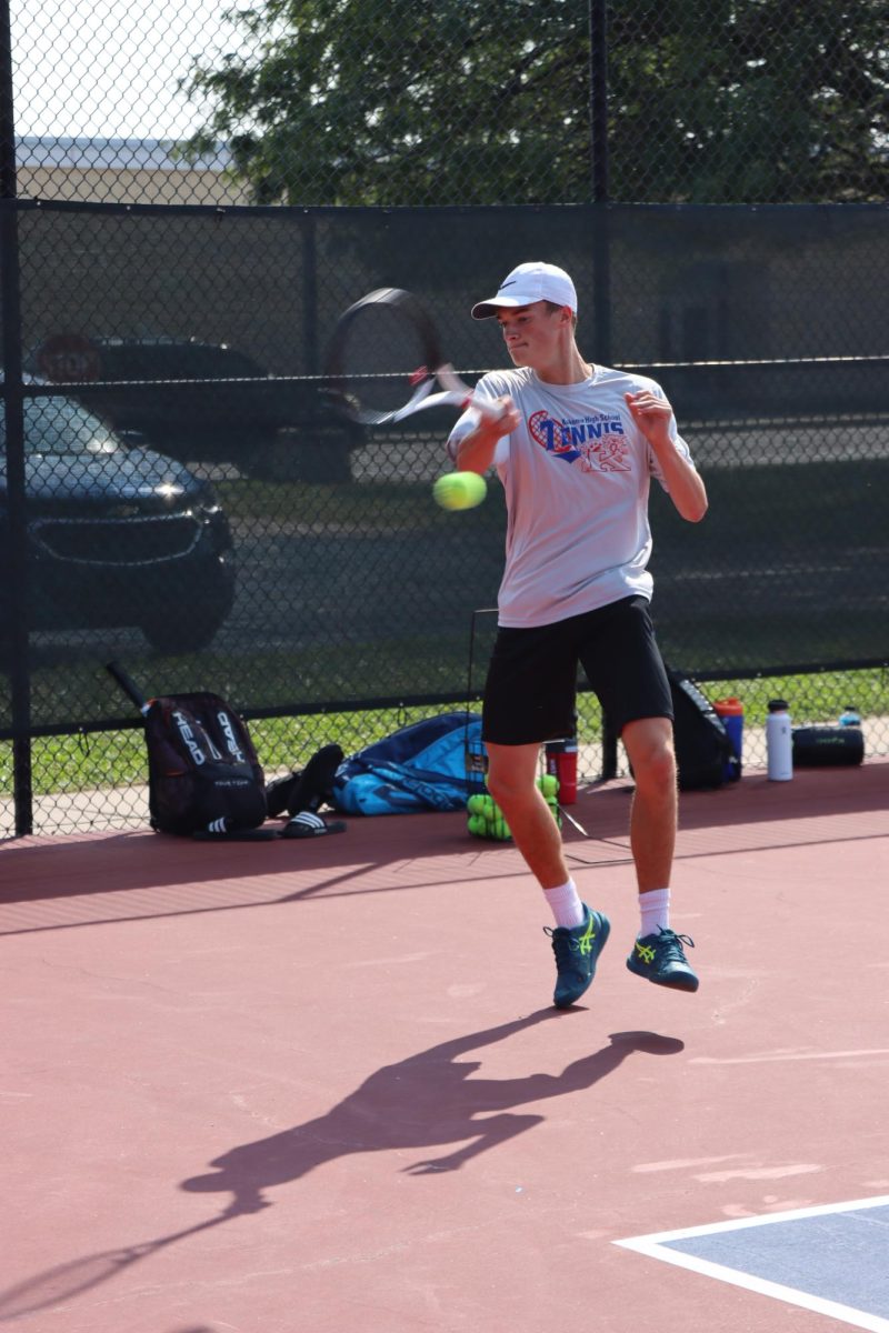 Junior Caleb Taflinger returns the ball during warm ups before a match against Maconaquah. The Kats beat the Braves, 5-0. 