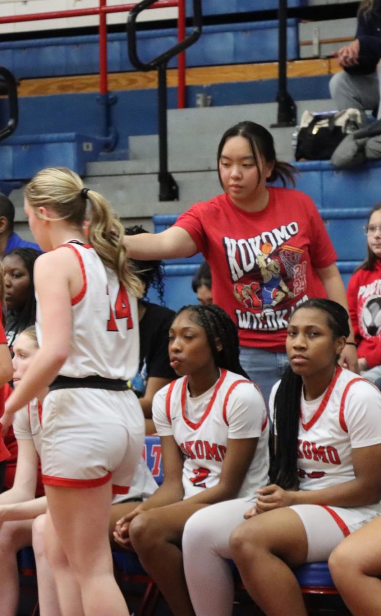 Girls' basketball manager senior Cha Cha Santipanarux gives senior Regan McClain her water during a game. One of the managers' responsibilities is to make sure each player's water bottle stays filled. 