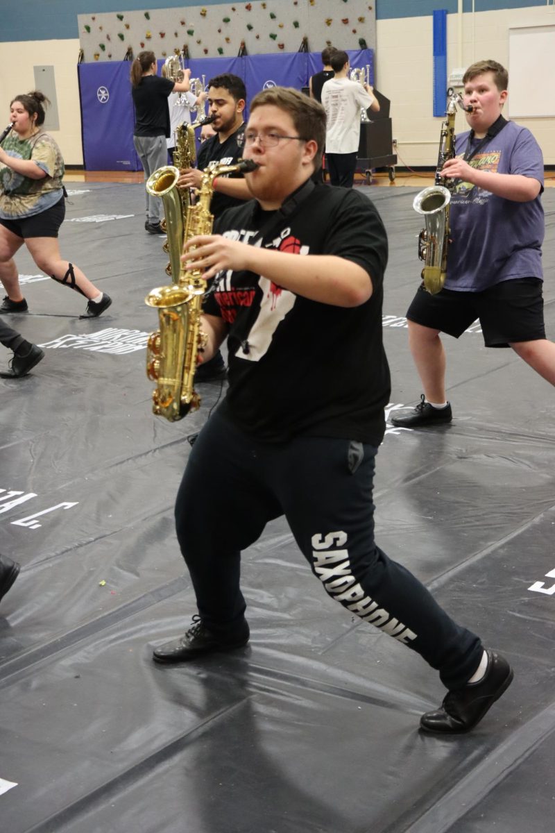 Senior Noah Birdsong performs with the indoor winds at their community performance before their first competition. The ensemble is trying to defend their state title. 