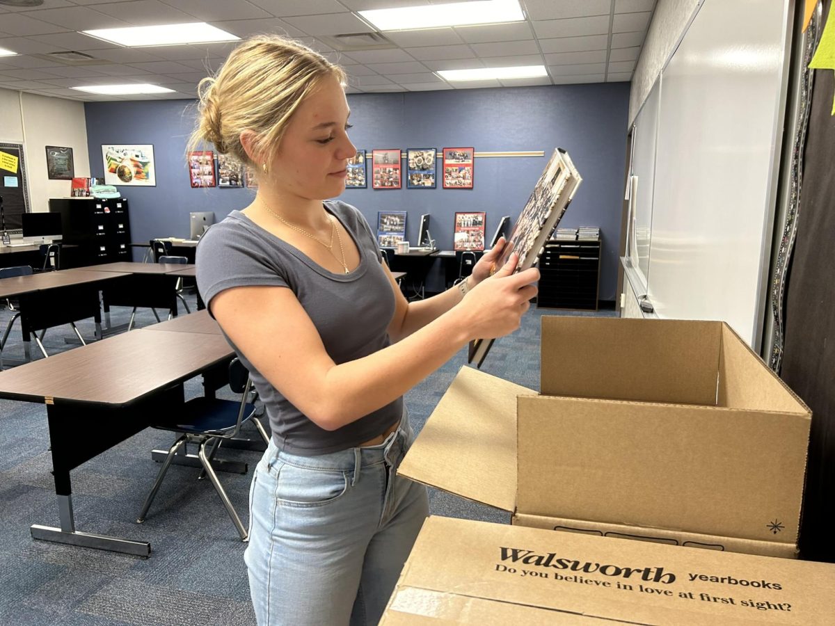 Yearbook editor, senior Regan McClain, unboxes last year's book. 2025 yearbooks are on sale now at yearbookforever.com.