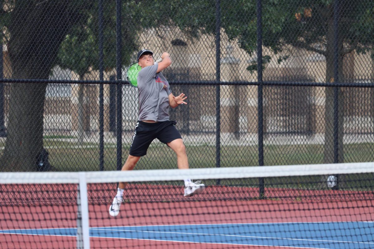 Senior Caleb Taflinger returns the ball during a home match against Eastern. Taflinger now holds the record for singles wins at KHS with 67.